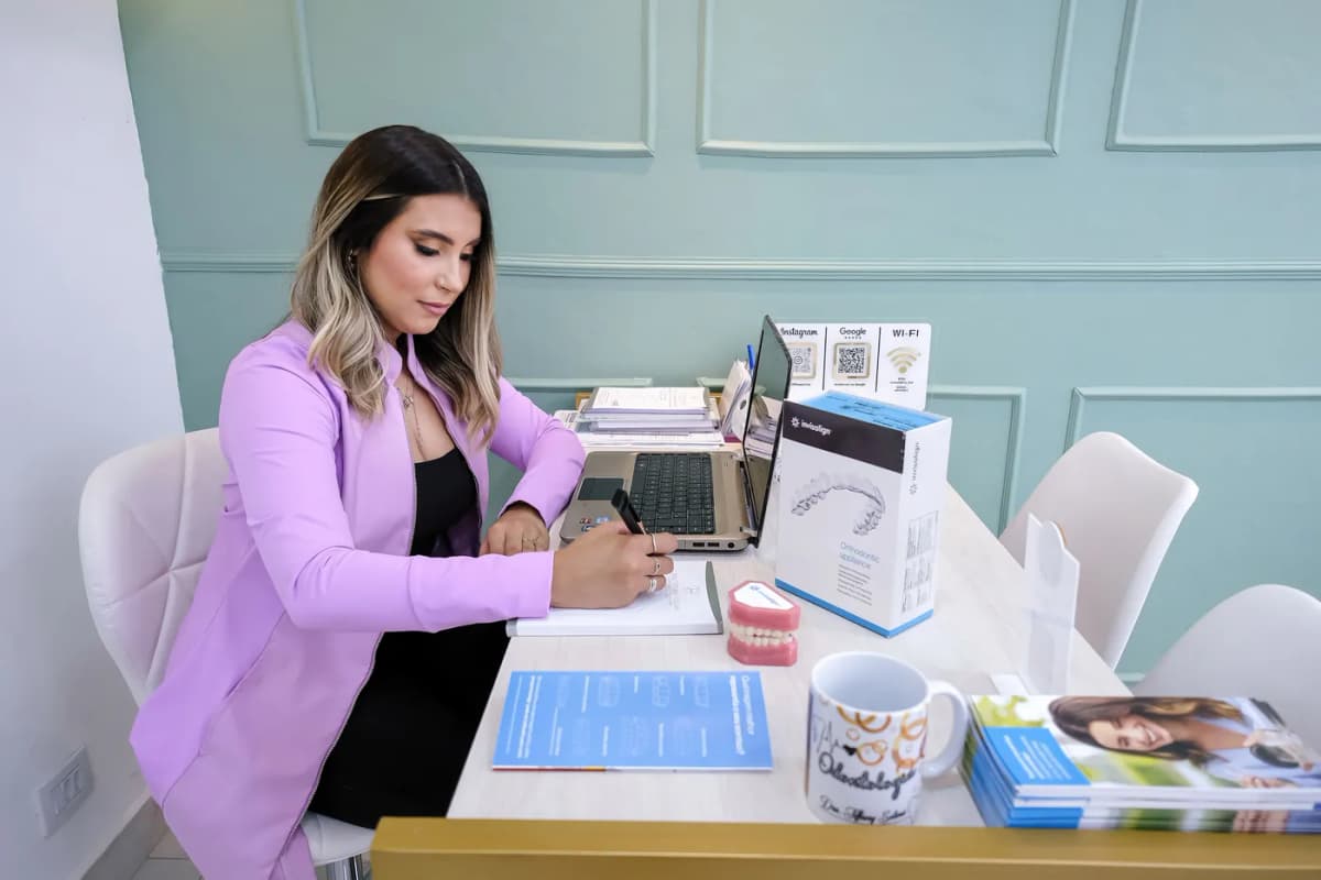 Dra. Tiffany Solimã preparando um plano de tratamento em sua mesa no consultório